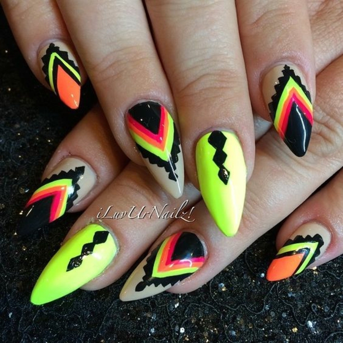 acid green or yellowish nail polish, decorated with black, red and orange hand-drawn elements, on oval pointy nails