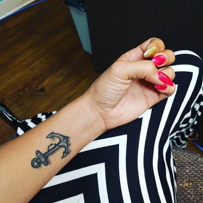 hot pink and gold, long sharp nails, worn by tan woman, with a dark gray anchor tattoo, featuring a chain with a small semicolon, semicolon tattoo meaning, long striped black and white skirt