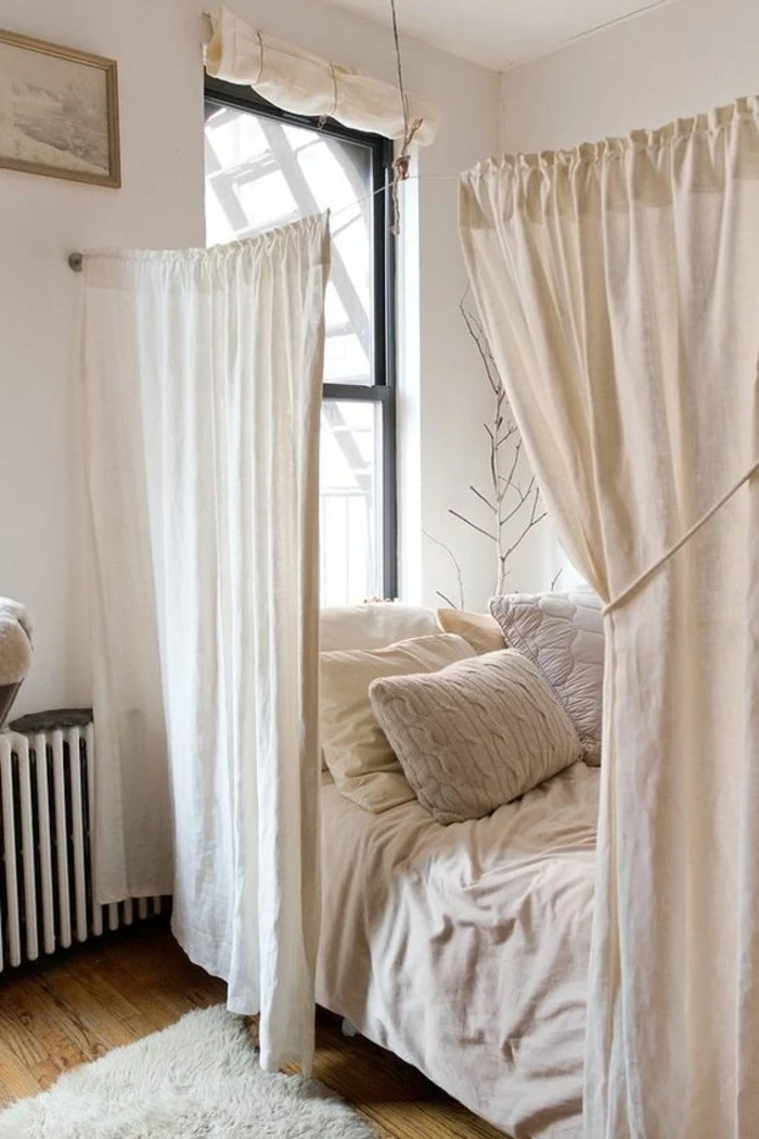 studio apartment ideas, half-drawn ivory-colored curtains, separating a bed from the rest of the room, studio apartment ideas, laminate floor with fluffy off-white rug