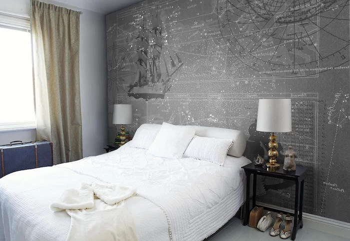 compass and a ship, star maps and constellations, on a grey wallpaper, near a soft white bed, bedroom wall decor, matching bedside tables with identical lamps