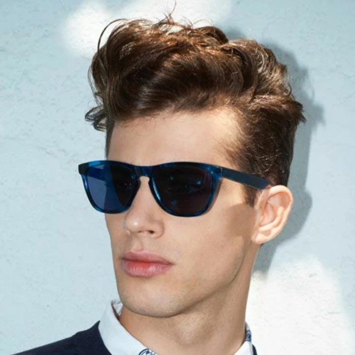 hairstyles for short curly hair, youth with dark blue sunglasses, wearing a pompadour, made from his brunette curly hair