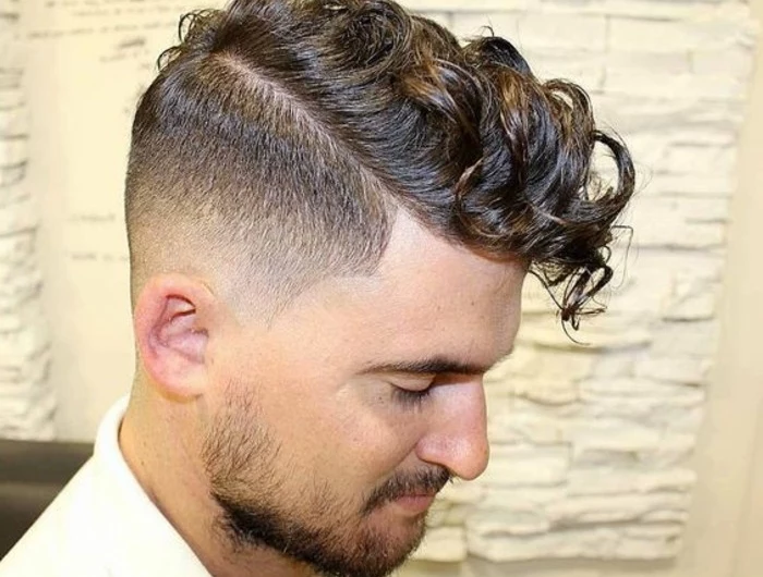 undercut with curly hair, on brunette man in profile, with short beard and mustache, wearing white shirt, curly hairstyles,