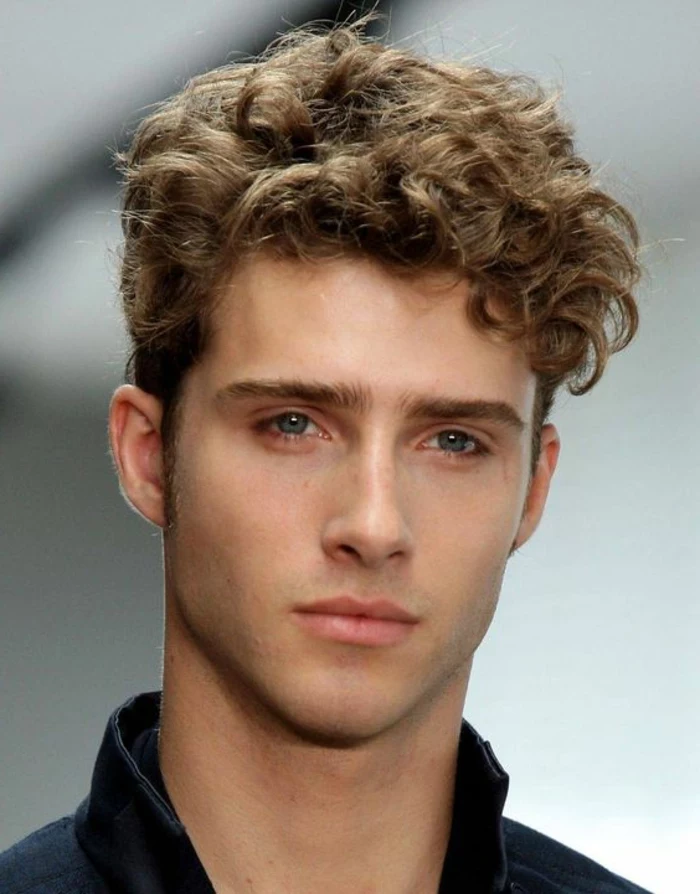 dark blonde hair, long on top, and shorter on the sides, worn by slim young man, with blue eyes, hairstyles for curly hair