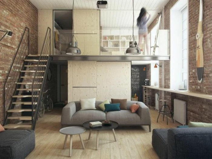 how to decorate a studio apartment, small industrial style home, on two levels, with metal staircase, modern pale gray sofa, and two round coffee tables