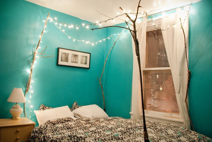 wall decor ideas, room with turquoise walls, and a white ceiling, lit string lights suspended from four dry tree branches, placed around a double bed