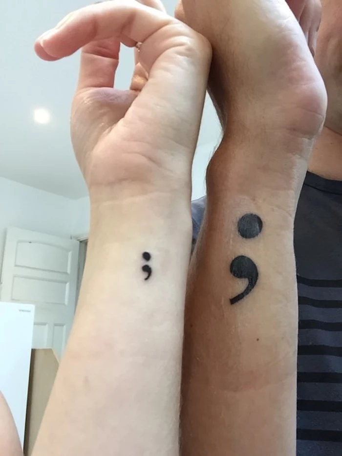 male hand with large black semicolon tattoo, and female hand with small black semicolon tattoo, matching tattoos for couples, semicolon meaning 