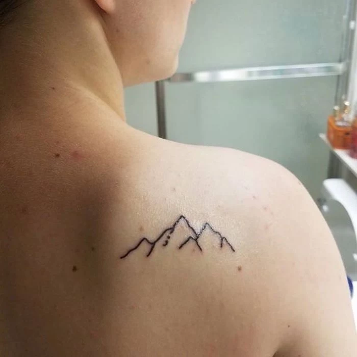purpose of semicolon, minimalist back tattoo of a mountain, lineart in black, with a small, barely visible semicolon, tattooed near a person's shoulder