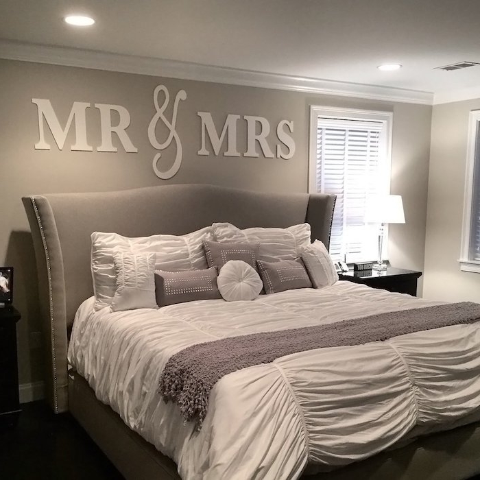 creamy gray wall, decorated with large white letters, spelling Mr & Mrs, wall decor ideas, near large gray double bed, with various cushions and throws
