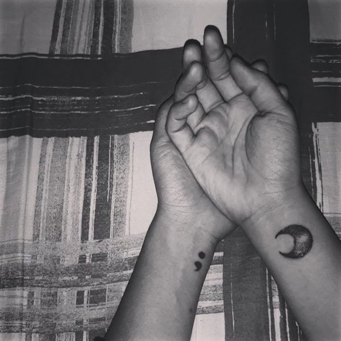 moon shape and semicolon, tattooed in black, on the wrists of two hands, purpose of semicolon, black and white photo, palms on top of each other