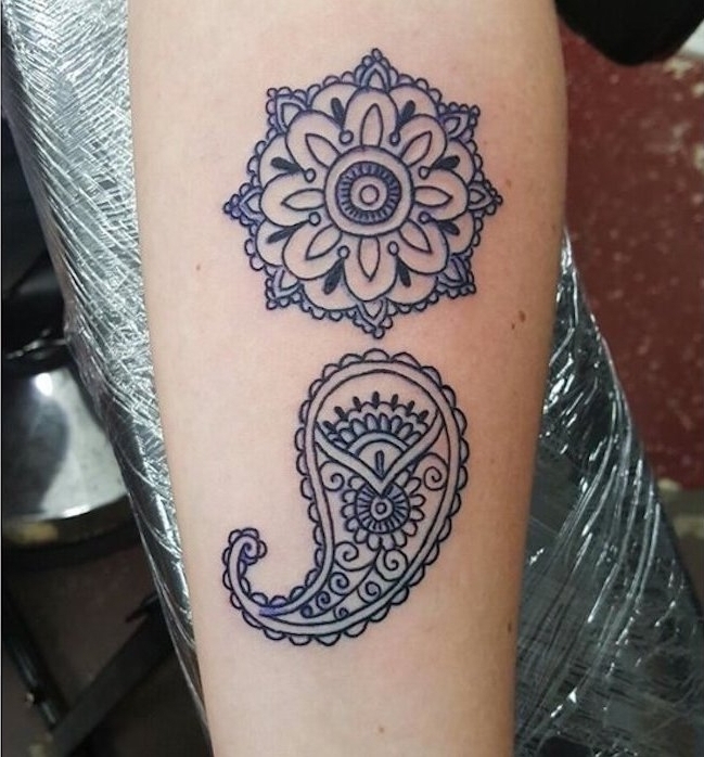 mandala with floral patterns, tattooed over a paisley shape, forming a large semicolon, done in dark blue ink, semicolon meaning, on the inside of a person's arm