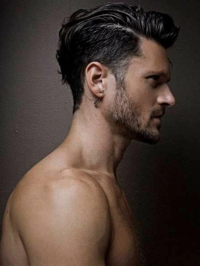 topless brunette man in profile, haircuts for curly hair, undercut with deep side part, and bangs slicked to one side