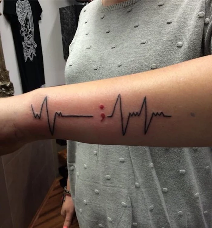 lifeline tattoo in black, punctuated by a small red semicolon, on the side of a person's lower arm, ideas for the semicolon project 