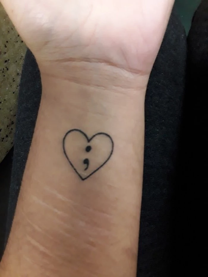 semicolon tattoo on wrist, black semicolon sign, inside a simple heart outline, on a scarred wrist
