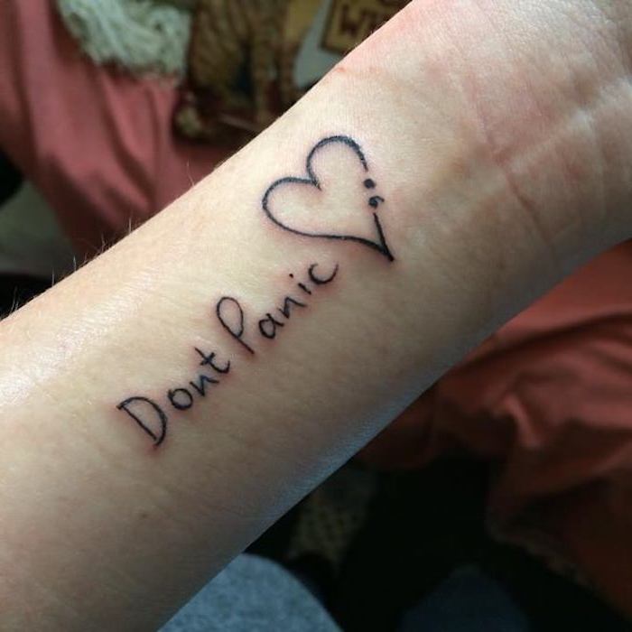 don't panic tattooed in black, near a heart shape, decorated with a semicolon, semicolon tattoo on wrist, with some faded scars