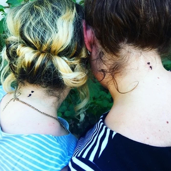 friendship matching tattoos, on the back of the neck, semicolon movement tattoos, worn by two women, with hair tied up, blonde and brunette