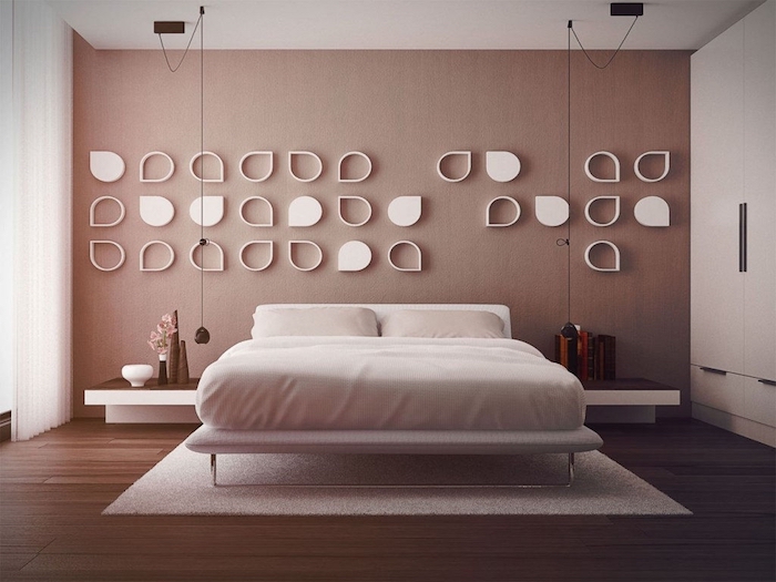 wall art décor, white hollow and solid, symmetrical tear-shaped decorations, on a pastel pink wall, in a modern minimalistic bedroom