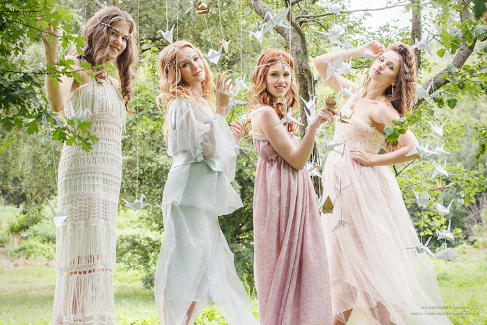 crochet lace dress in white, floaty pale blue gown, pink maxi dress, and white tulle dress with lace, worn by four young women, dressy casual style, boho tea party