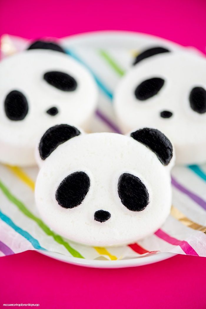 panda bear diy bath bombs, in white and black, placed on multicolored striped paper, placed over a white dish