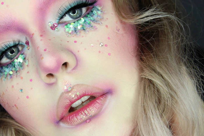 close up of a girl's face, makeup looks, sparkly pink lips, blue eye shadow, with chunky iridescent turquoise glitter, purple contouring and fake lashes