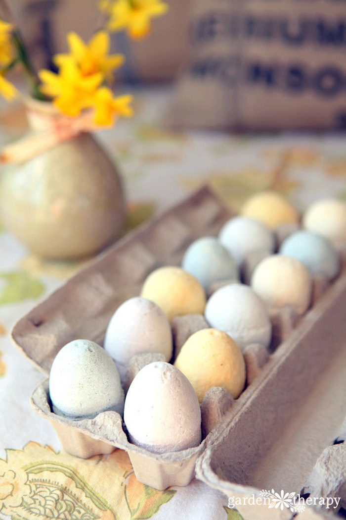 festive easter-themed bath bombs, shaped like eggs, in pale pastel colors, twelve in total, placed in a cardboard box