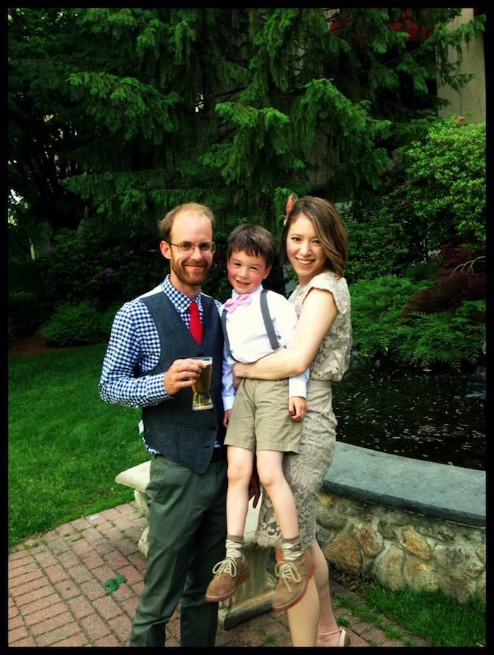 family posing for a photo, wearing semi formal clothes, with a retro twist, checkered blue shirt and red tie, vest and trousers, shorts and suspenders, with white shirt and bowtie, beige dress and high heels