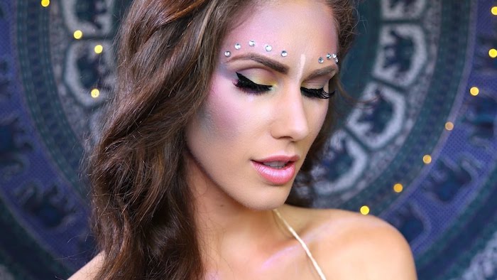 3D pearl-shaped stickers in silver, decorating the forehead of a slim woman, with long wavy brown hair, make up ideas, pink lipstick and black eyeliner, blue and pink blush