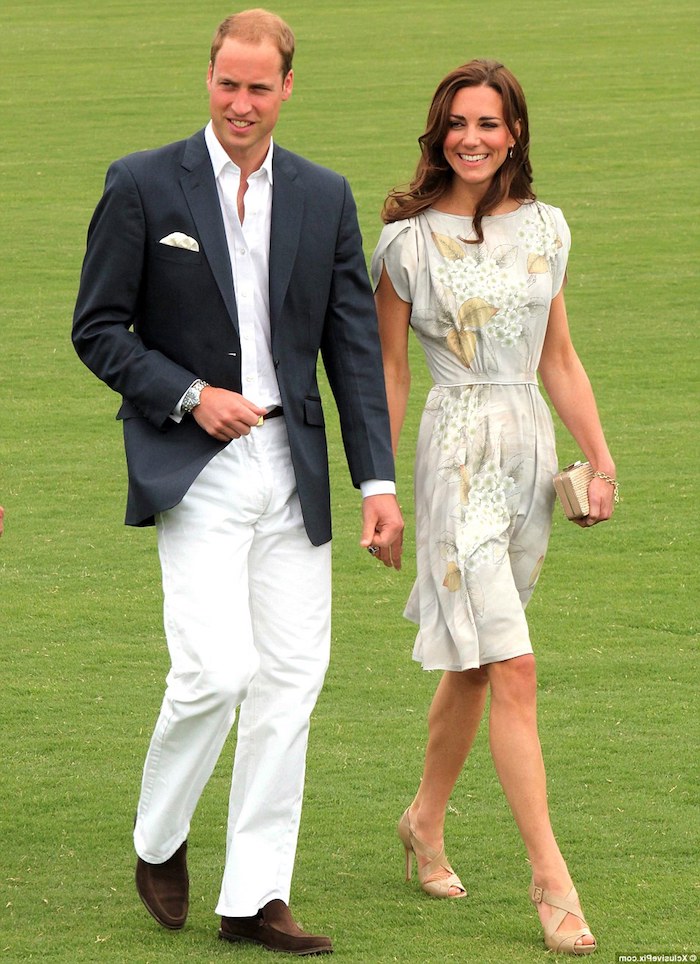 kate middleton and prince william, walking on a green field, dressed in garden party attire, pale beige knee-length dress, with pale floral pattern, white trousers and shirt, with black blazer