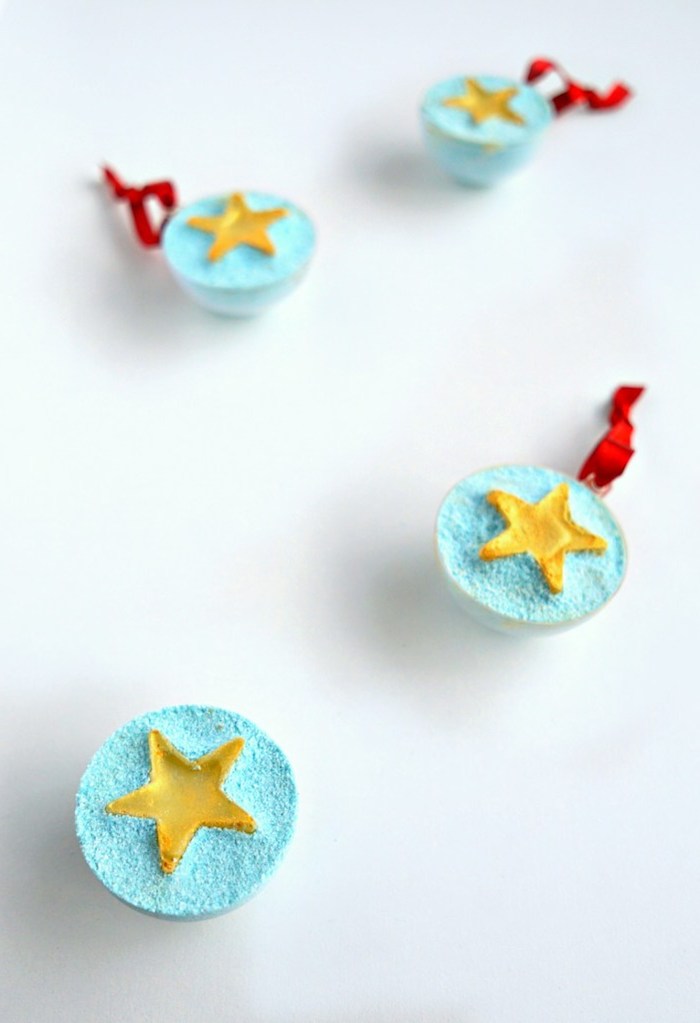 us flag inspired bath bombs, light blue and tied with red ribbons, each decorated with a yellow star, shaped like half spheres