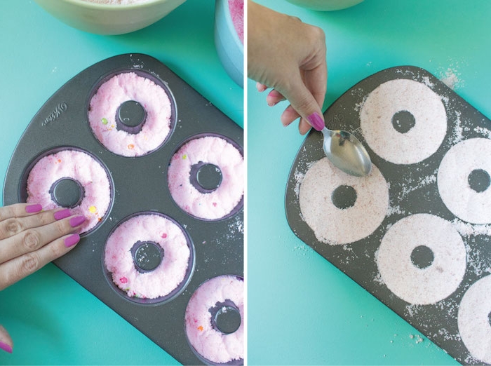 pressing white powder, into black teflon donut mould, using a metal spoon, making bath bombs, smoothing pink powder on top