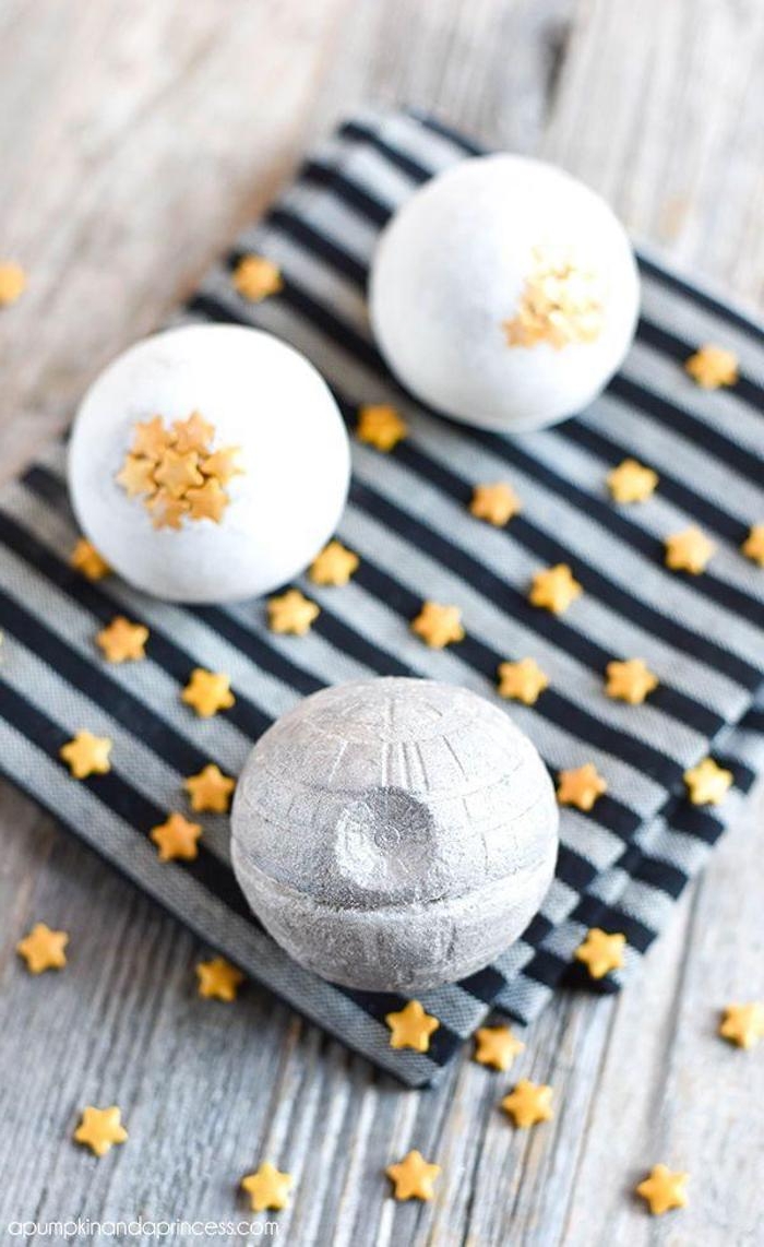 bath fizzies inspired by star wars, miniature pale gray death star, two white bath bombs, decorated with little yellow stars