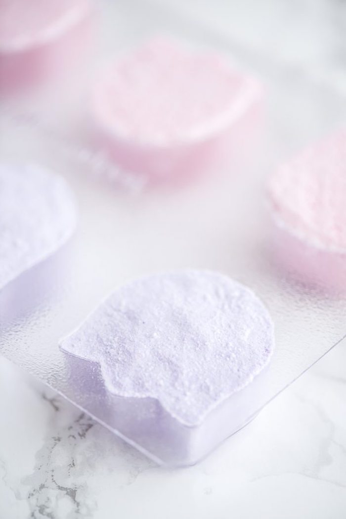 clear plastic mould, with compartments shaped like tulips, filled with pale violet and pale pink powder, diy bath bombs 