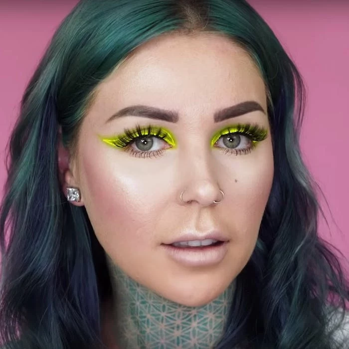 neon yellow eyeliner, worn with long, black fake lashes, and nude pink lipstick, by young woman, with turquoise hair, and nose rings