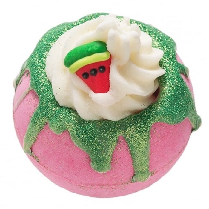 pink and sparkly green bath bomb, decorated with cream-like topping, and a small watermelon slice figurine