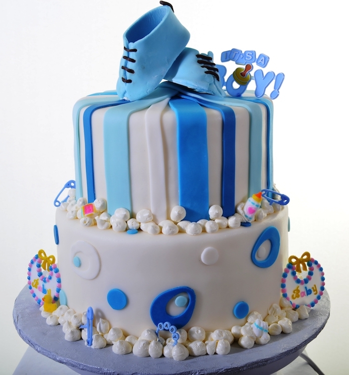 sugar pearls and decorations, made from blue and white fondant, pair of small shoes, stripes and oval shapes, on a two-layered cake, baby shower cakes for boys