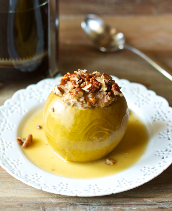 whole yellow apple, cored and baked, stuffed with walnuts and honey, and placed on an ornate white plate, breakfast menu ideas 