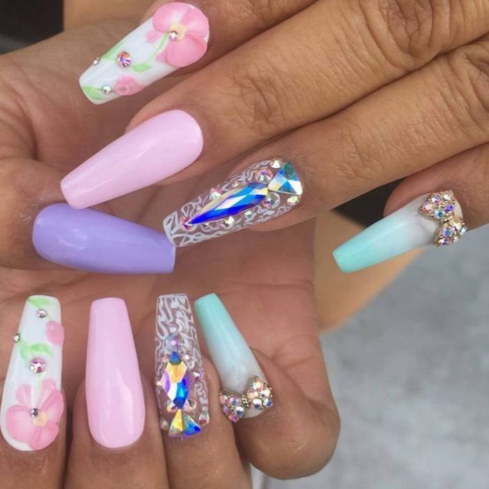 pastel colored acrylic nail shapes, in white and pale pink, light purple and pale milky blue, decorated with floral motifs, rhinestone shapes and artificial gems