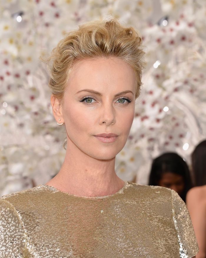 hairstyles for women with thin hair, charlize theron with wavy, short pixie cut, styled upwards like a pompadour, wearing a golden sequin dress