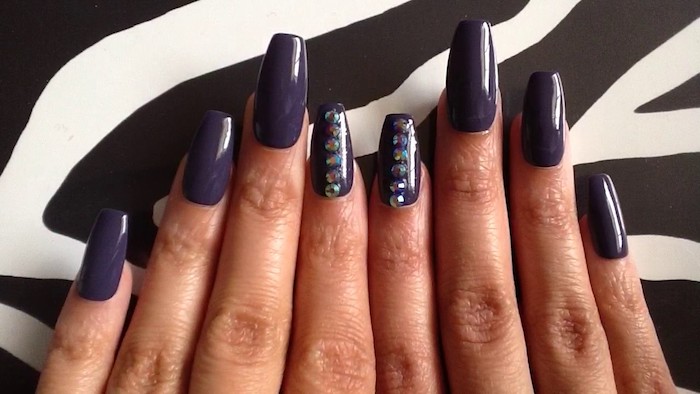 violet dark and smooth nail polish, on eight long nails, coffin nail designs, both index finger nails are decorated with several rhinestones