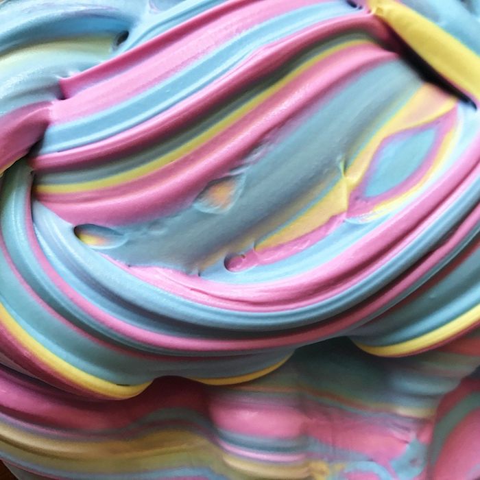 close up of twisted multicolored goo, soft and foamy, and striped in different pastel colors, how to make fluffy slime, pink and blue, yellow and green