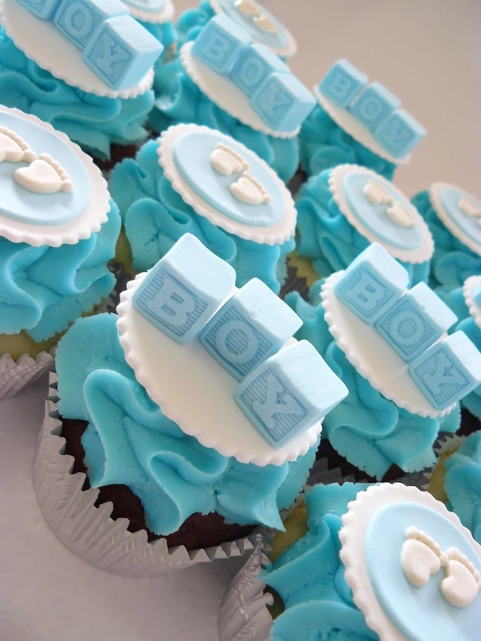 baby shower cakes for boys, cupcakes with turquoise frosting, decorated with white and blue fondant shapes, little feet and alphabet blocks spelling boy