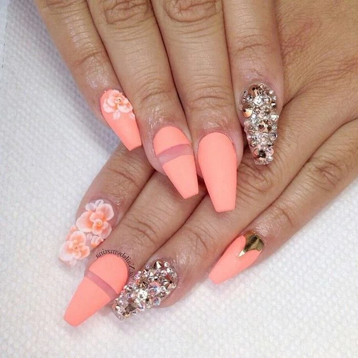 peach colored nail polish, decorated with acrylic flowers, and a golden metallic detail, rhinestones and clear stripes, squoval nails 