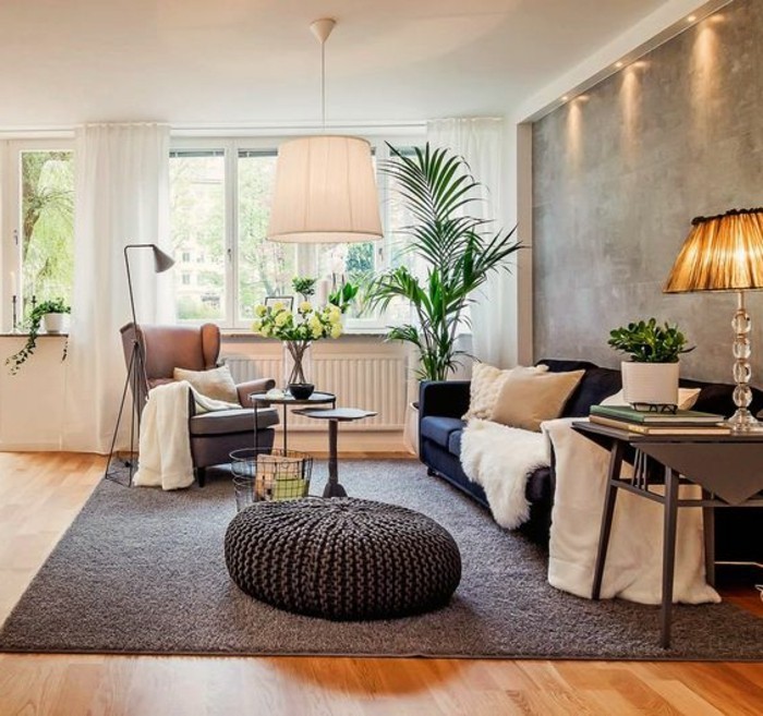 navy blue sofa, with two beige cushions, and a white fluffy throw, how to decorate a living room, beige armchair and a large, green potted plant, antique orange lamp 