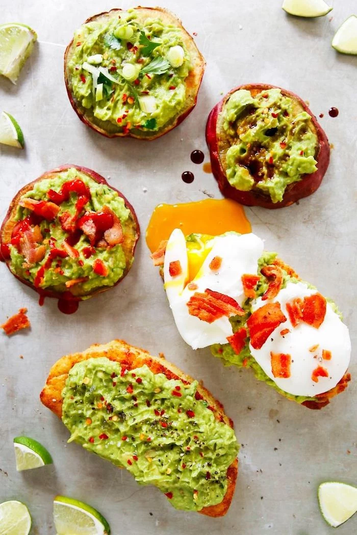 five different piece of bread, with guacamole spread, garnished with different toppings, low calorie breakfast, pepper and eggs, chili flakes and parsley