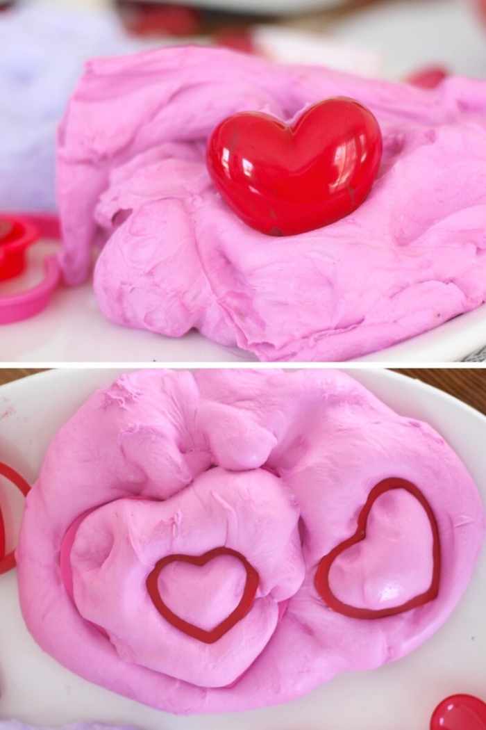 soft and fluffy elmer's glue slime, looking like pink cotton candy, with a small plastic red heart, and two heart shaped prints