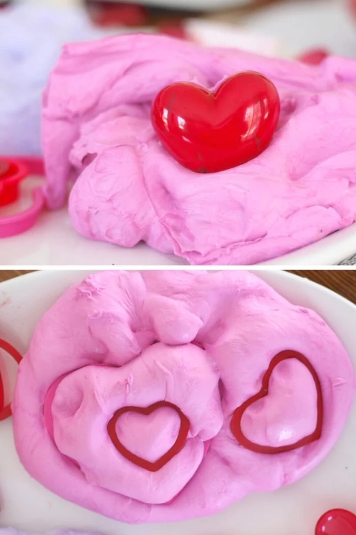 soft and fluffy elmer's glue slime, looking like pink cotton candy, with a small plastic red heart, and two heart shaped prints