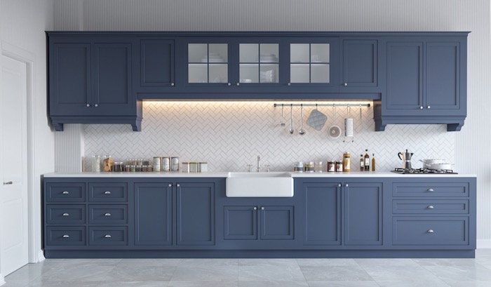 slate blue kitchen cabinets, in a room with marble tile floor, white counter tops, white kitchen backsplash, and various utensils