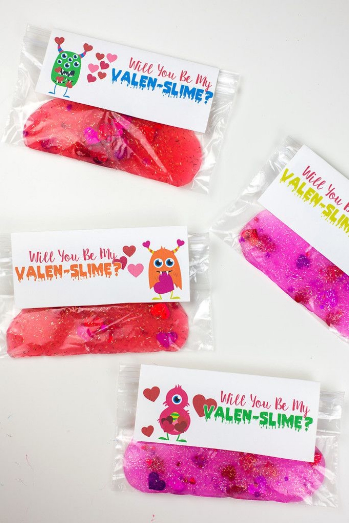 will you be my valen-slime, written on a white labels, with a drawings of different monsters, attached to sachets, containing red and pink slime, with added pink glitter hearts, how to make slime with glue, on a white surface