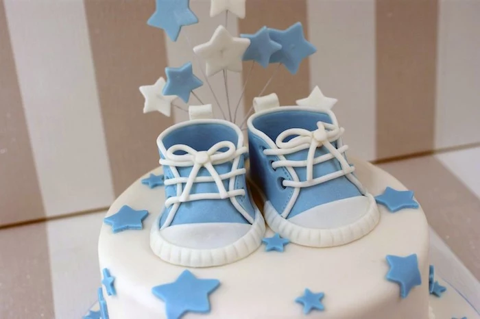 sneakers in pale blue and white, made from fondant, on top of a white cake, with smooth frosting, and pale blue stars, baby shower cakes for boys, star-shaped toppers