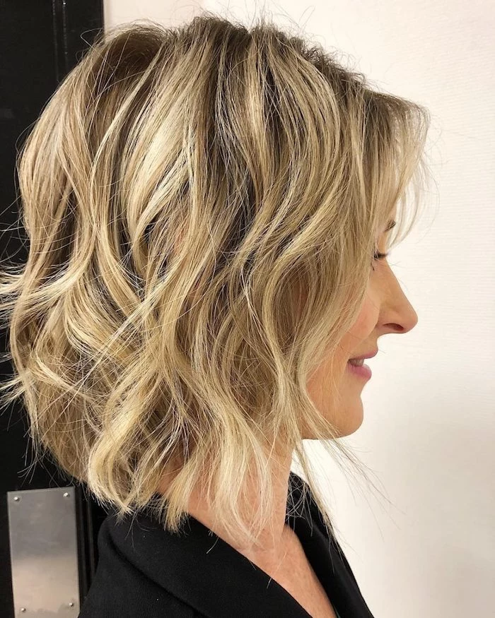 beach waves on a long, dark ash blonde bob, with light blonde balayage, on a woman in profile, medium length hairstyles for thin hair, wearing a black top