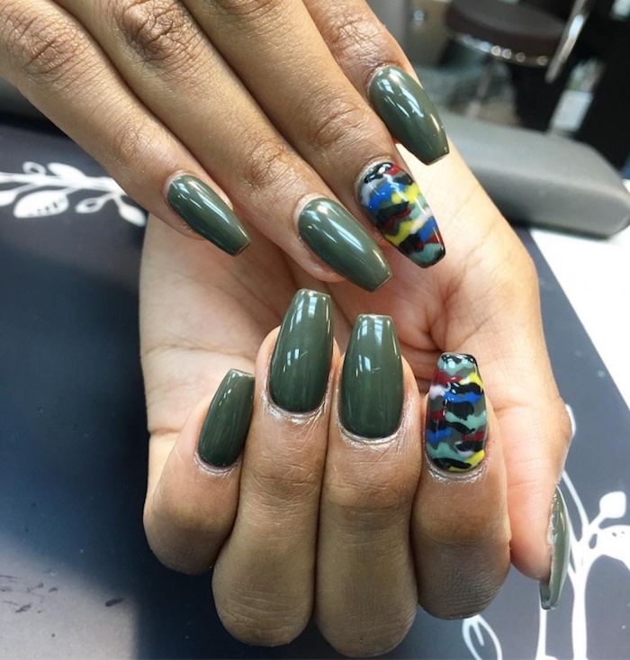 camouflage squoval nails in olive green, on a pair of tan hands, two of the nails are painted in a multicolored camouflage pattern